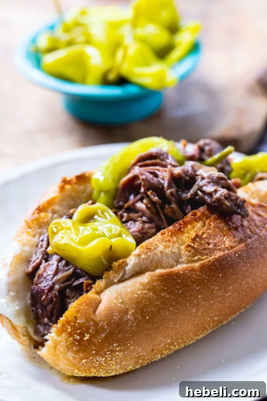 A generous serving of Slow Cooker Mississippi Beef with many pepperoncini peppers and a rich gravy.
