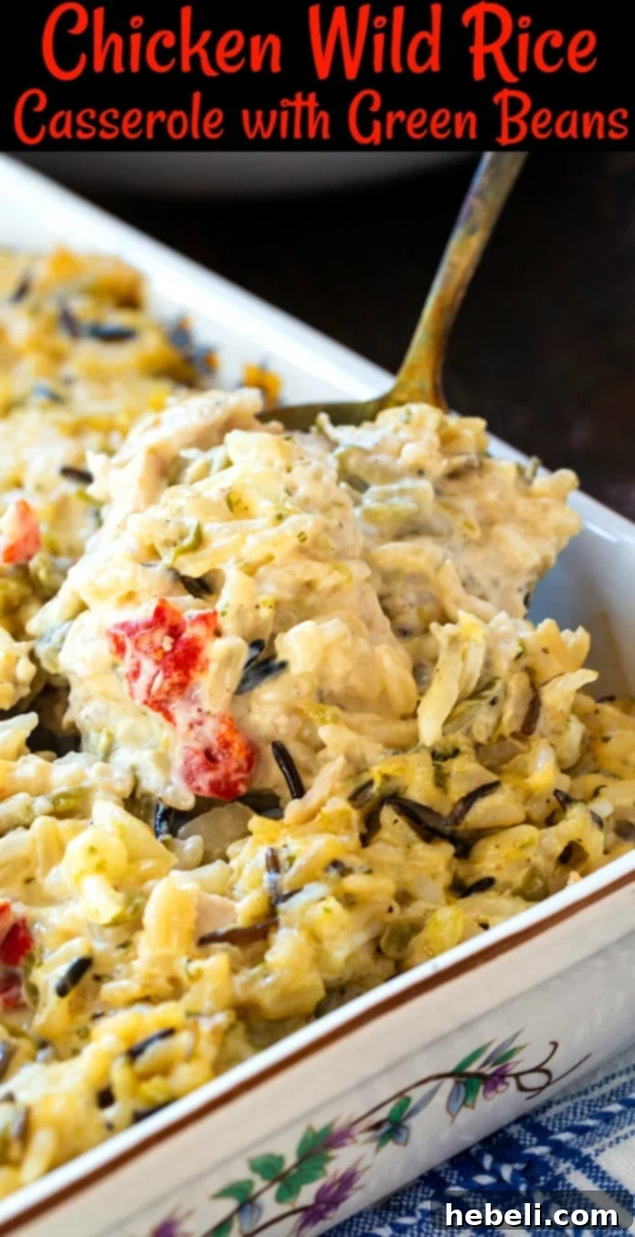 A spoon scooping a generous portion of the creamy Chicken Wild Rice Casserole, showing its rich texture.