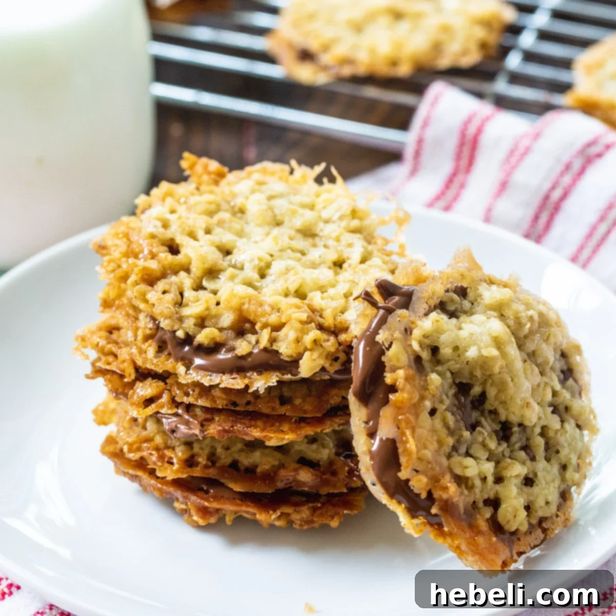 Stacked Chocolate Florentine Cookies on a elegant white plate, showcasing their intricate lace pattern and creamy chocolate filling.