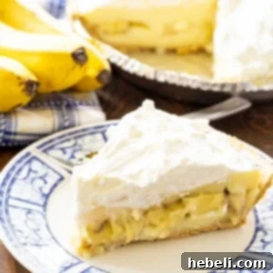 A beautiful slice of Banana Cream Pie on a blue and white plate, ready to be enjoyed.