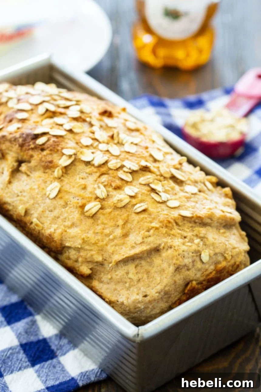 Golden Honey Oat Loaf 3 A perfectly baked loaf of Honey Oat Wheat Bread with golden crust and visible oats, ready to be sliced.