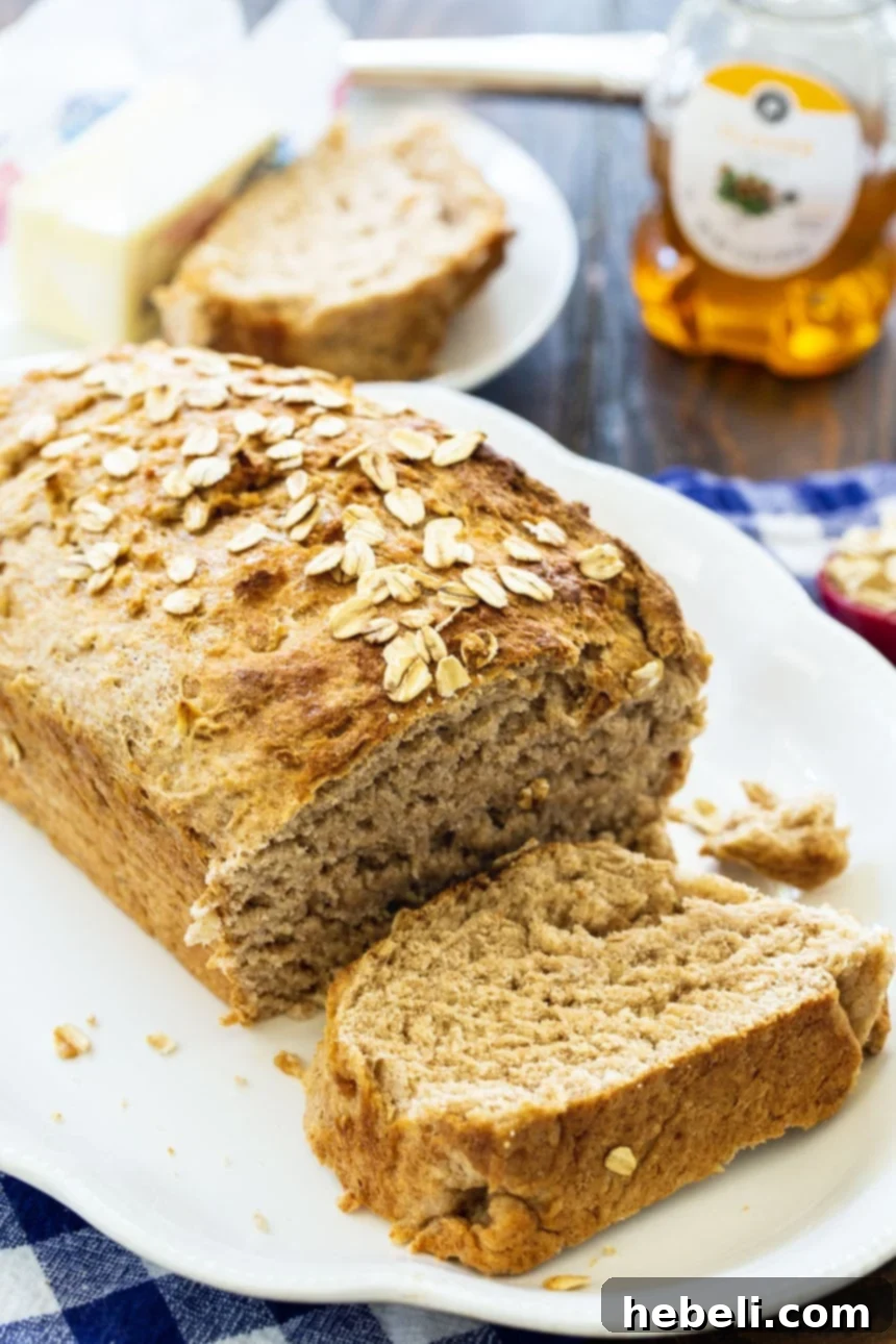 Golden Honey Oat Loaf 4 Slices of freshly baked Honey Oat Wheat Bread arranged on a white serving platter, showing its rich texture.