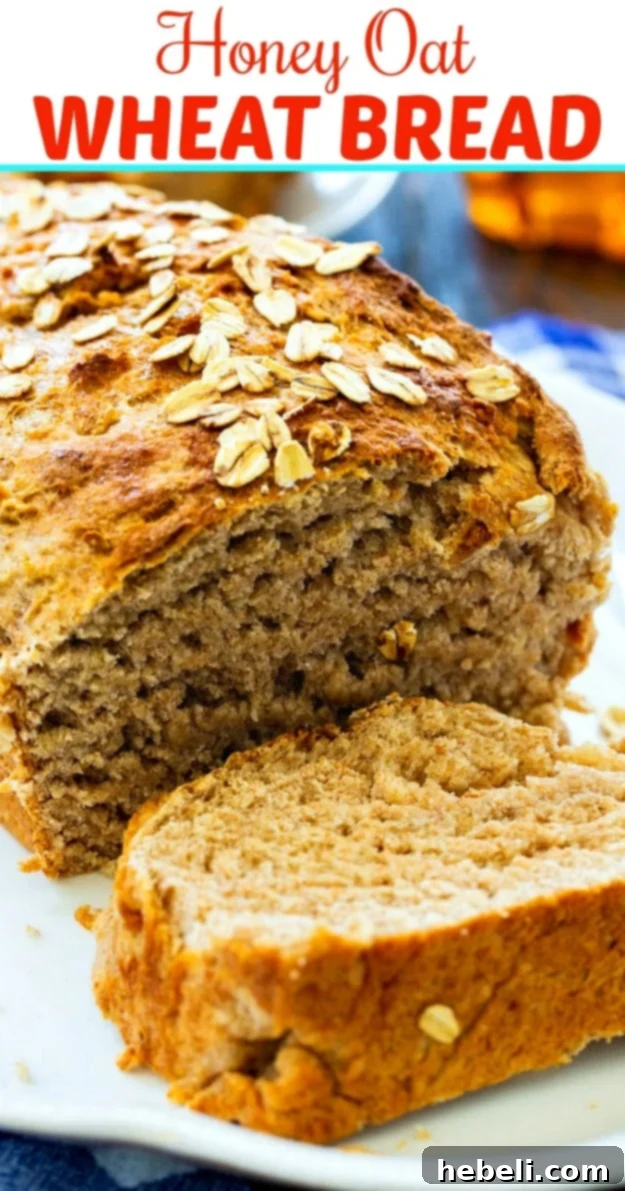 Golden Honey Oat Loaf 6 A beautifully sliced loaf of Honey Oat Wheat Bread on a white serving platter, revealing its soft, airy texture.