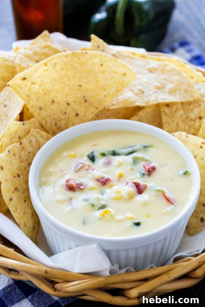 Smoky Poblano and Sweet Corn Queso 4 Appetizing close-up of Poblano and Corn Queso in a small white ramekin, garnished with fresh cilantro, ready to be enjoyed.