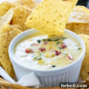 Smoky Poblano and Sweet Corn Queso 5 Poblano and Corn Queso with tortilla chips, close up.
