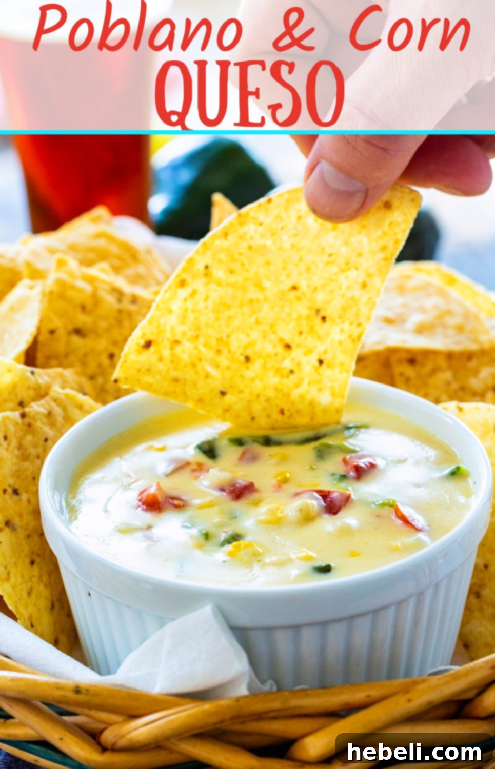 Smoky Poblano and Sweet Corn Queso 6 Close-up of a single tortilla chip scooping a generous amount of creamy Poblano and Corn Queso, showcasing its texture and ingredients.
