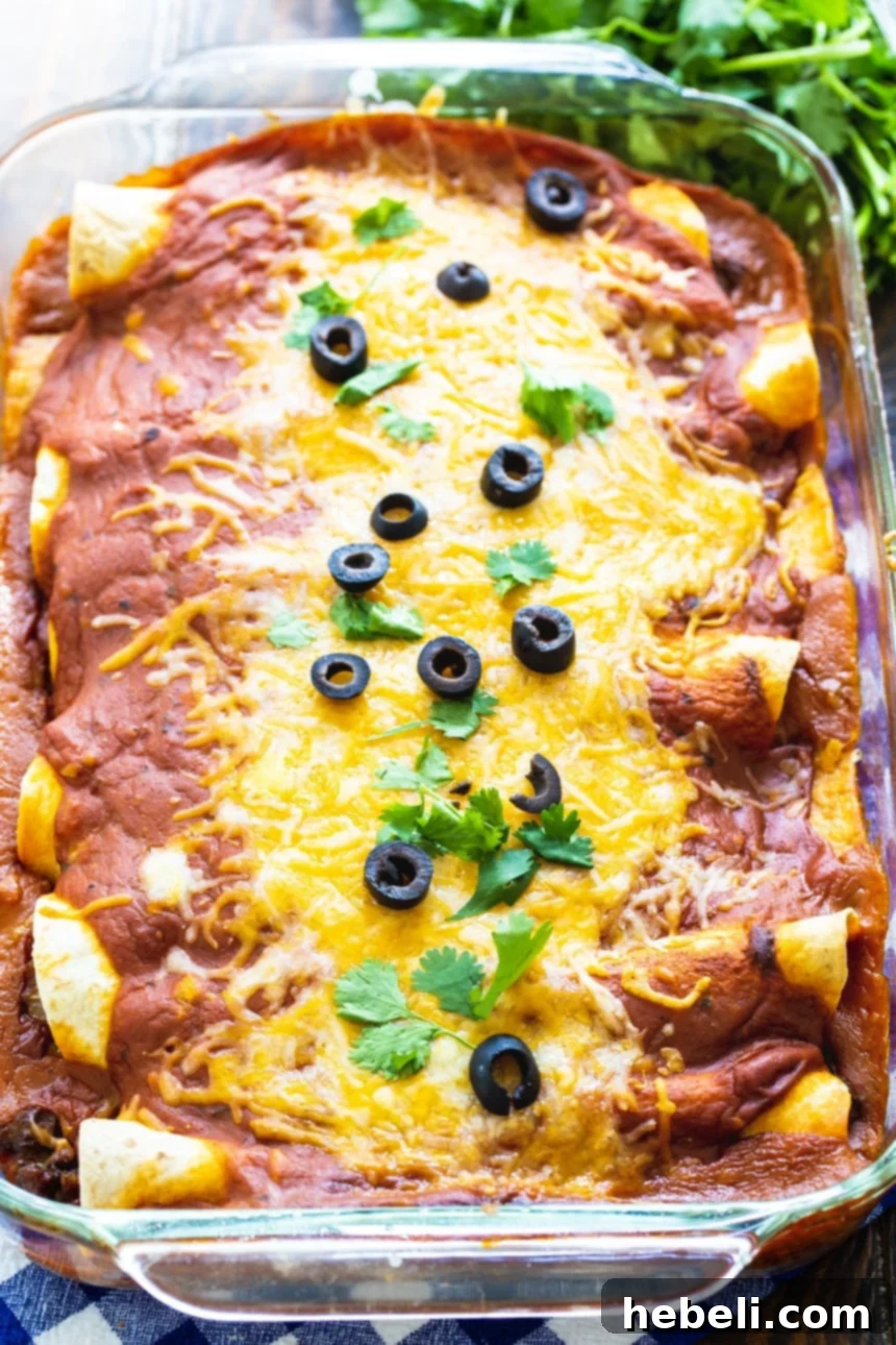 Kıymalı Enchilada 3 Ground Beef Enchiladas baking in a 9x13-inch dish, covered in red sauce and cheese.