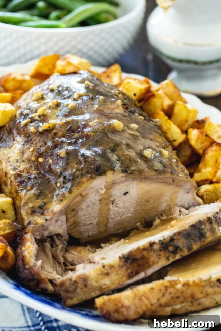 Slow Cooker Garlic Butter Pork Roast on a serving platter, generously covered with homemade gravy, highlighting its delicious appearance.