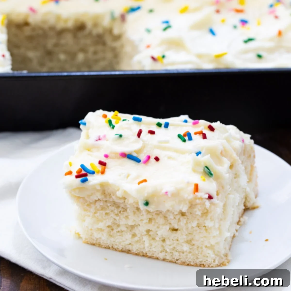 Slice of Doctored Cake Mix White Sheet Cake on a plate, ready to be enjoyed.