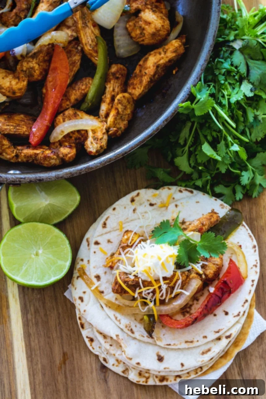 Zesty Sizzling Chicken Fajitas 4 A single Chicken Fajita wrapped in a flour tortilla, garnished with fresh cilantro, ready to be enjoyed.