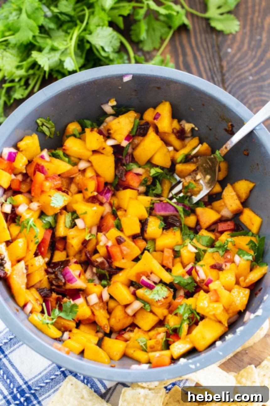 Smoldering Peach Salsa 4 Chipotle Peach Salsa presented in a large, elegant blue ceramic bowl, highlighting its fresh ingredients and inviting texture.