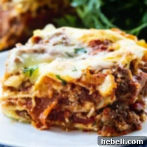 Velvety Cream Cheese Lasagna 6 A vibrant close-up of a slice of Cream Cheese Lasagna on a plate, highlighting the rich cheese and meat layers.