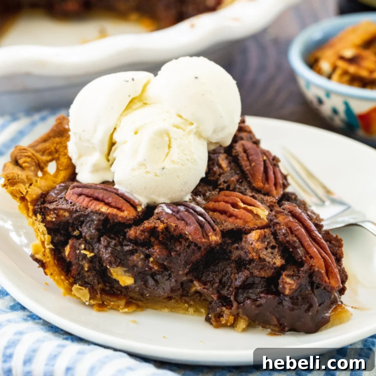 A perfectly sliced Mocha Pecan Pie topped with a generous swirl of fresh whipped cream, showcasing its rich, dark filling and abundant pecan topping.