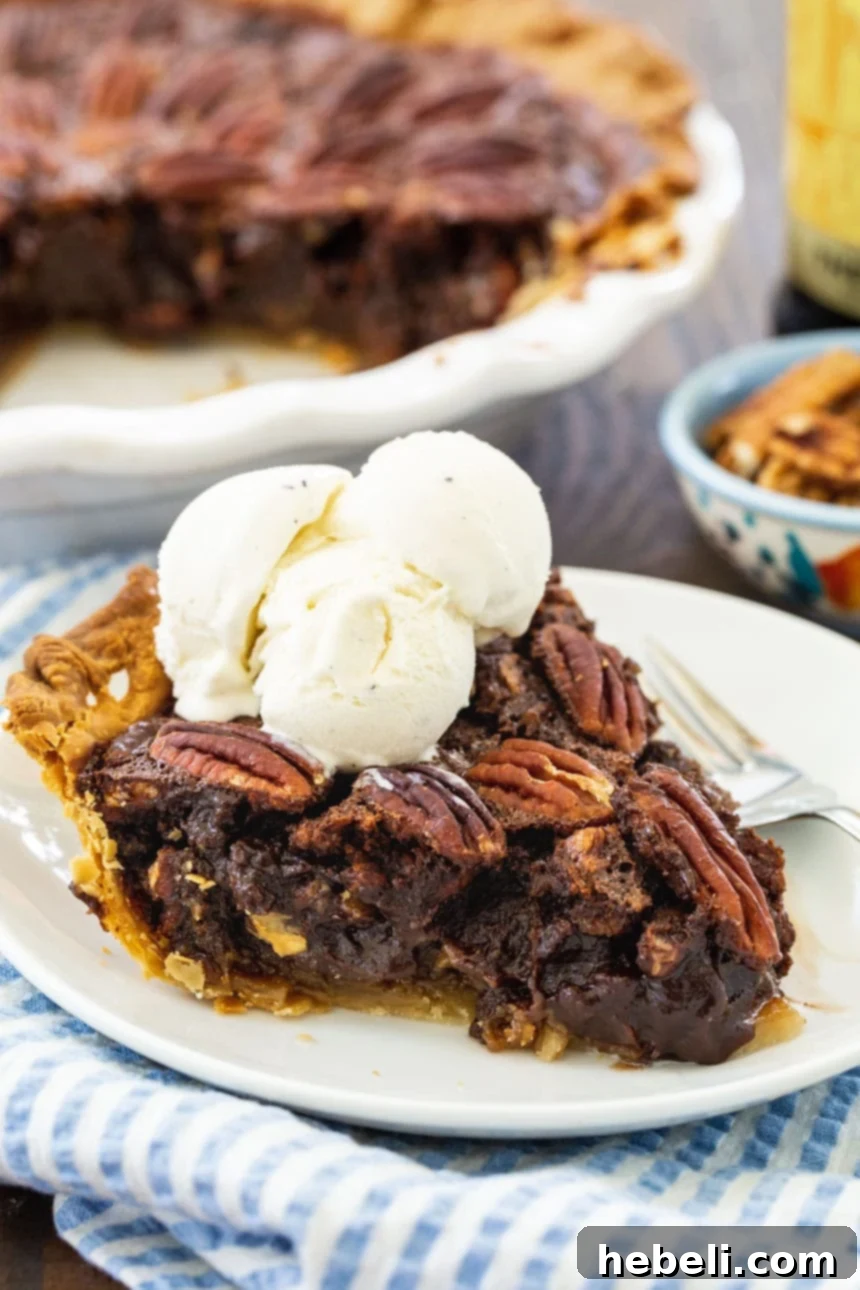 A mouth-watering slice of Mocha Pecan Pie, garnished with a scoop of creamy vanilla ice cream, showing the rich filling and crunchy pecan halves.