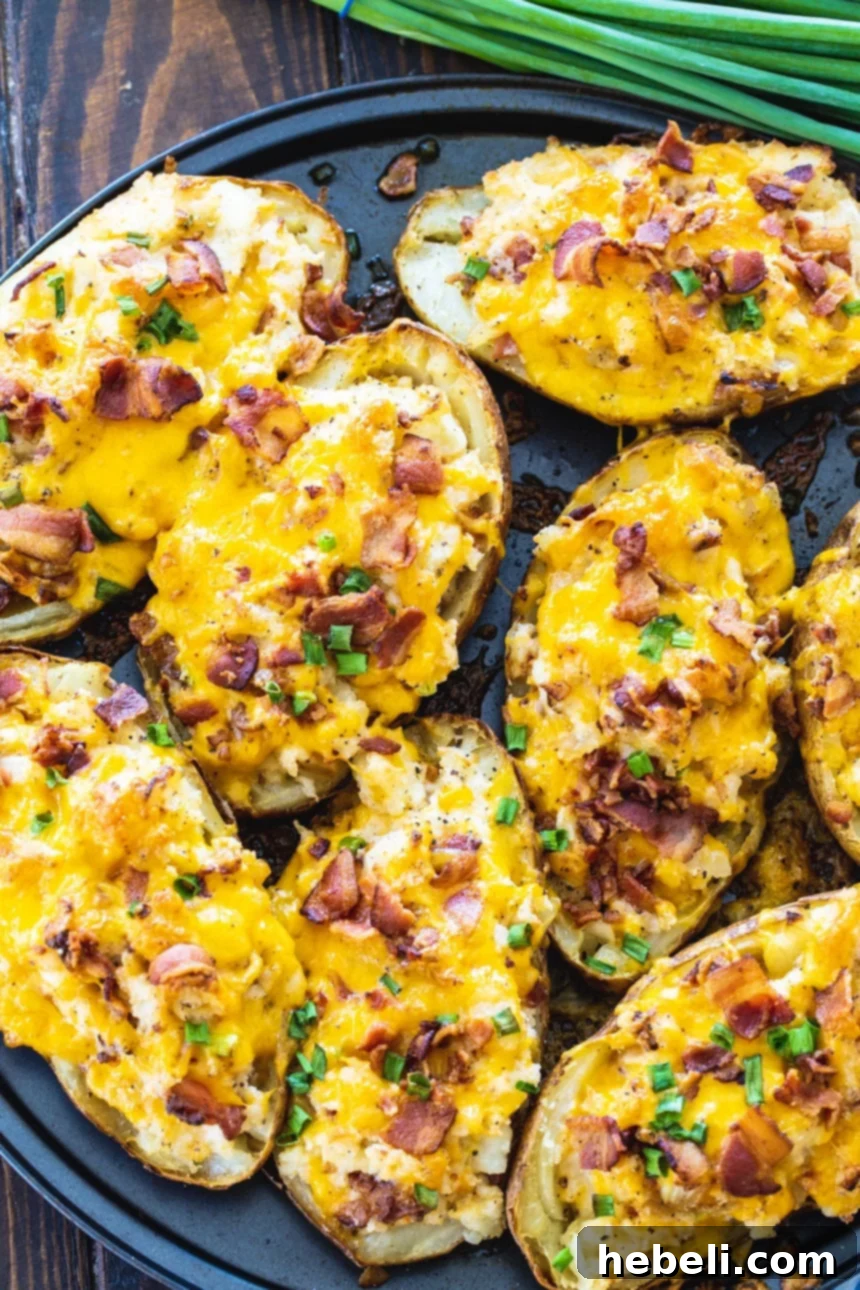 Twice Baked Potatoes garnished with fresh green onions in the background.