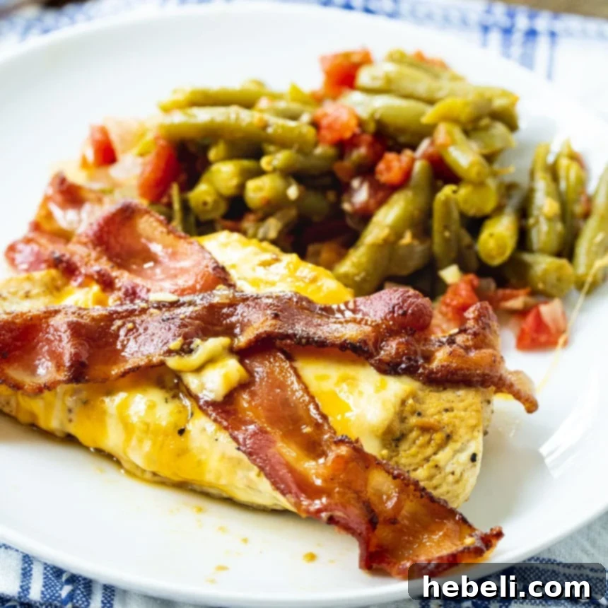 Maple Bacon Chicken Melt 2 Chicken served on a plate with green beans, garnished with crispy bacon and melted cheese.
