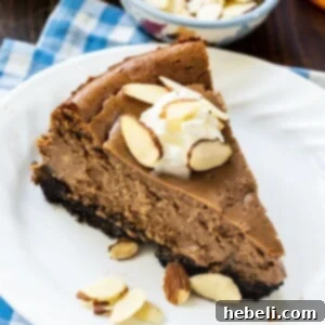 A close-up of a single slice of Chocolate Amaretto Cheesecake on a small white plate, ready to be served.