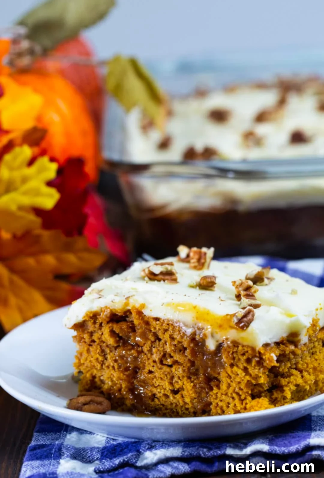 Another gorgeous slice of Pumpkin Caramel Poke Cake, highlighting the rich layers of cake, caramel, and frosting, ready for a fall indulgence.