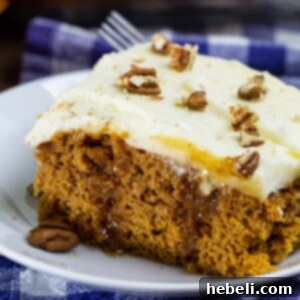 Finished Pumpkin Caramel Poke Cake with creamy frosting and pecans.