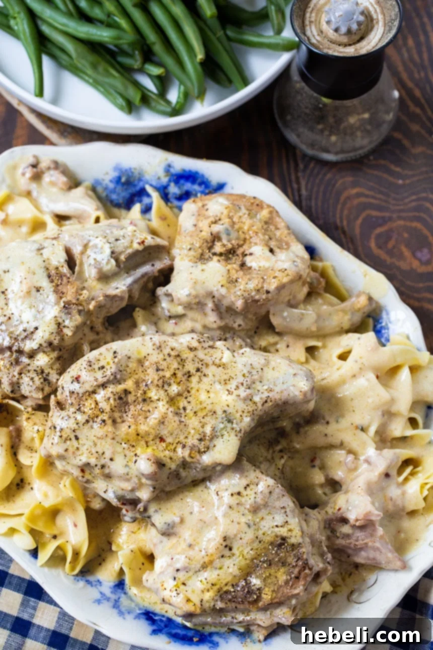 Creamy Ranch Pork Chops on a serving platter with green beans and fresh herbs.