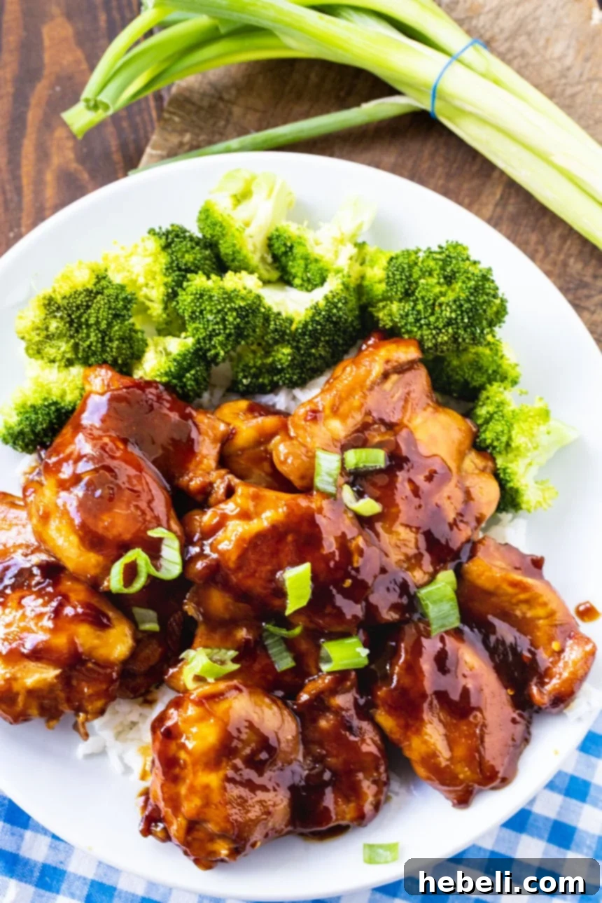 Overhead view of Teriyaki Chicken on a plate with broccoli and a spoon.