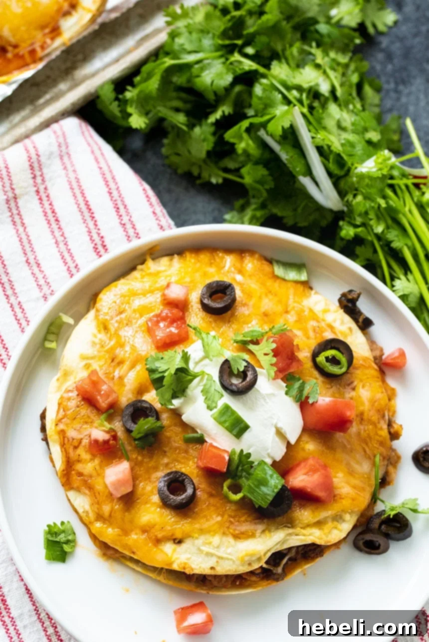 Overhead view of a finished Taco Bell Mexican Pizza on a white plate, showcasing the melted cheese and toppings.
