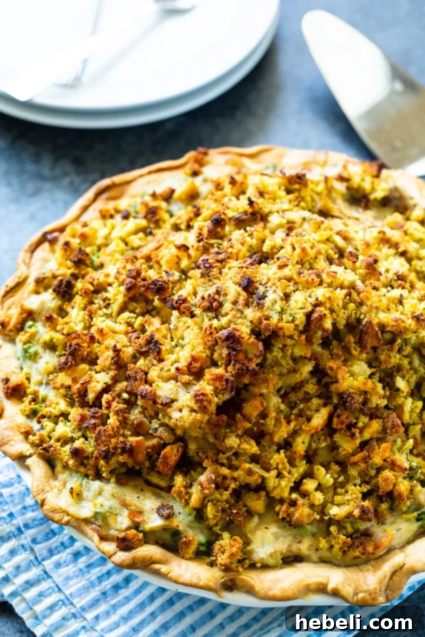 Savory Turkey Pot Pie with Stuffing Crust 3 A full Turkey Pot Pie in a ceramic pie plate, hot from the oven with a golden-brown stuffing topping.