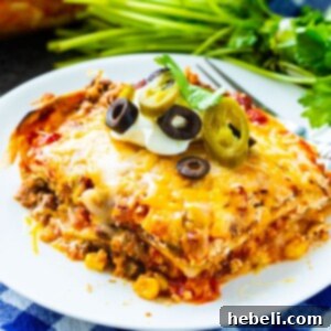 Slice of Mexican lasagna on a white plate, highlighting its rich textures and colors