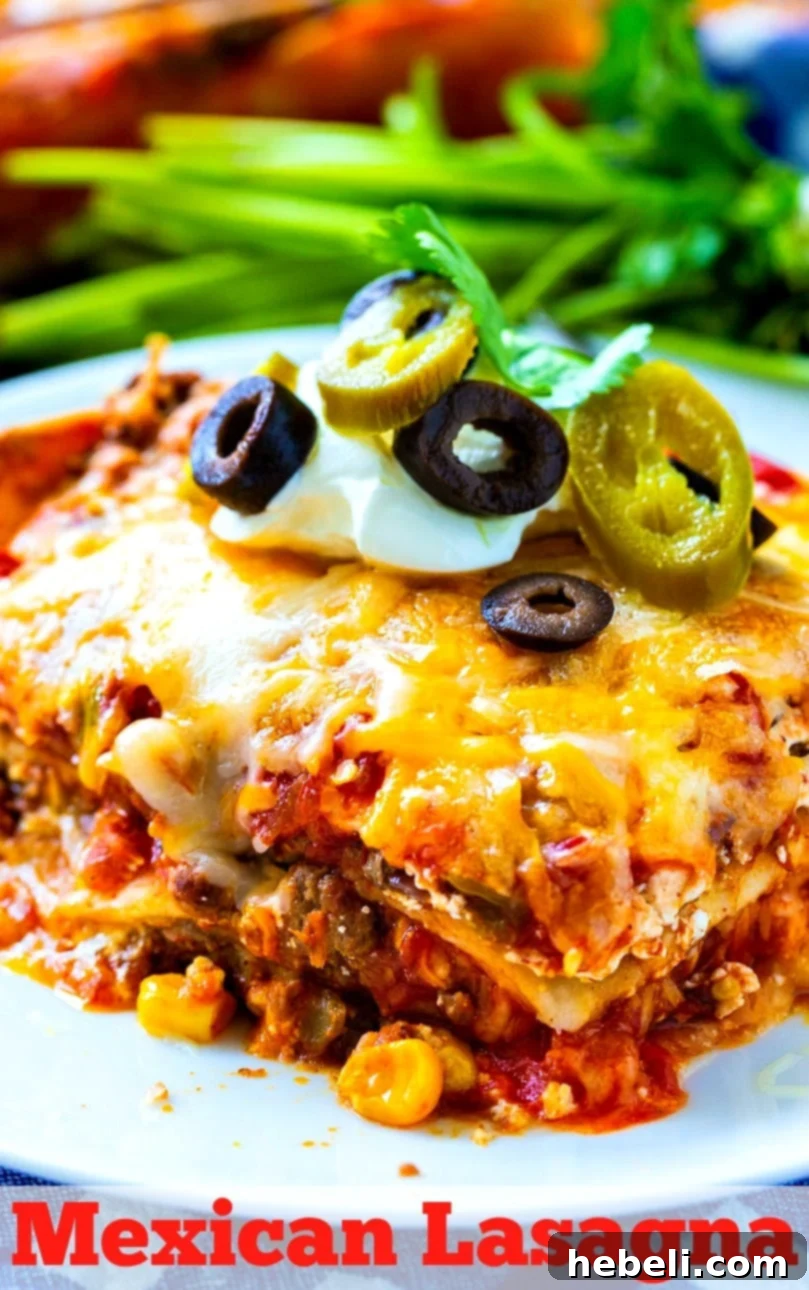 A large pan of freshly baked Mexican Lasagna, glistening with melted cheese and ready to be served.
