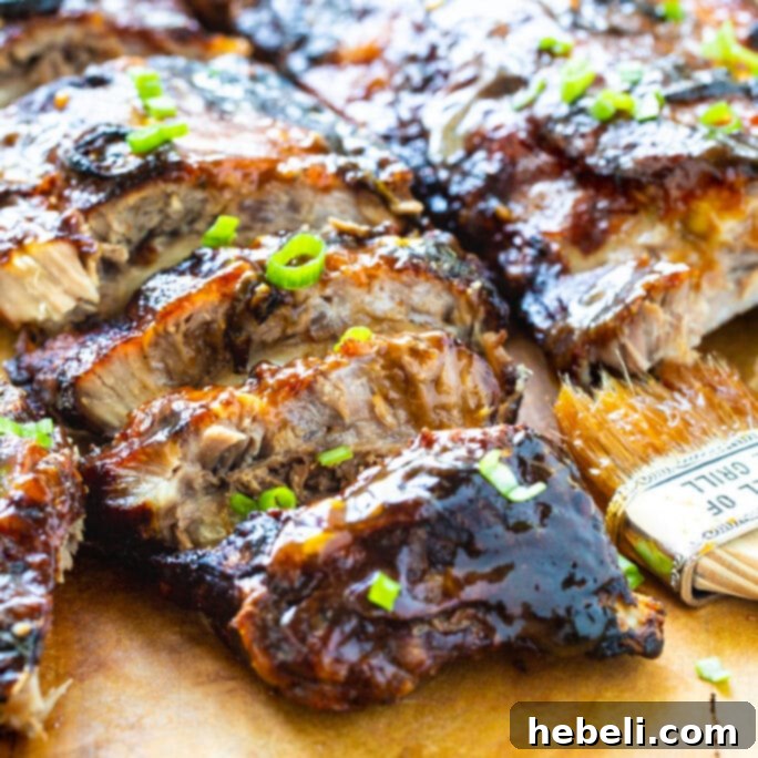Sticky Sweet & Sour Ribs 2 Perfectly glazed Sweet and Sour Baby Back Ribs resting on a rustic wooden cutting board, ready to be carved and served.