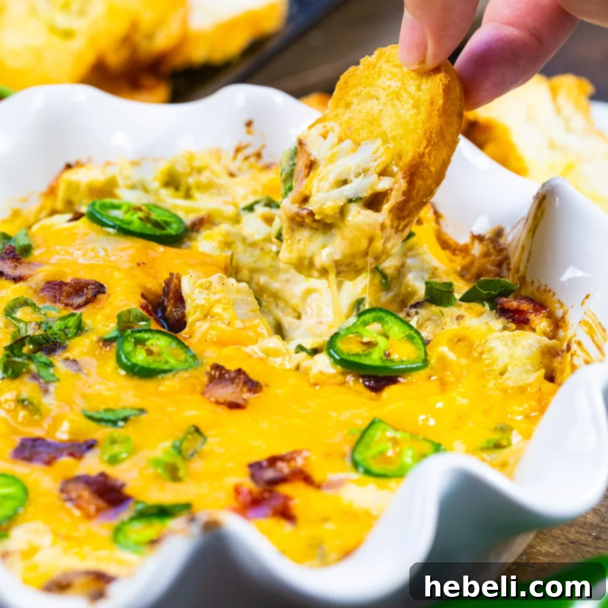 Creamy Jalapeno Crab Dip 2 Jalapeno Popper Crab Dip getting scooped up with piece of toasted baguette.