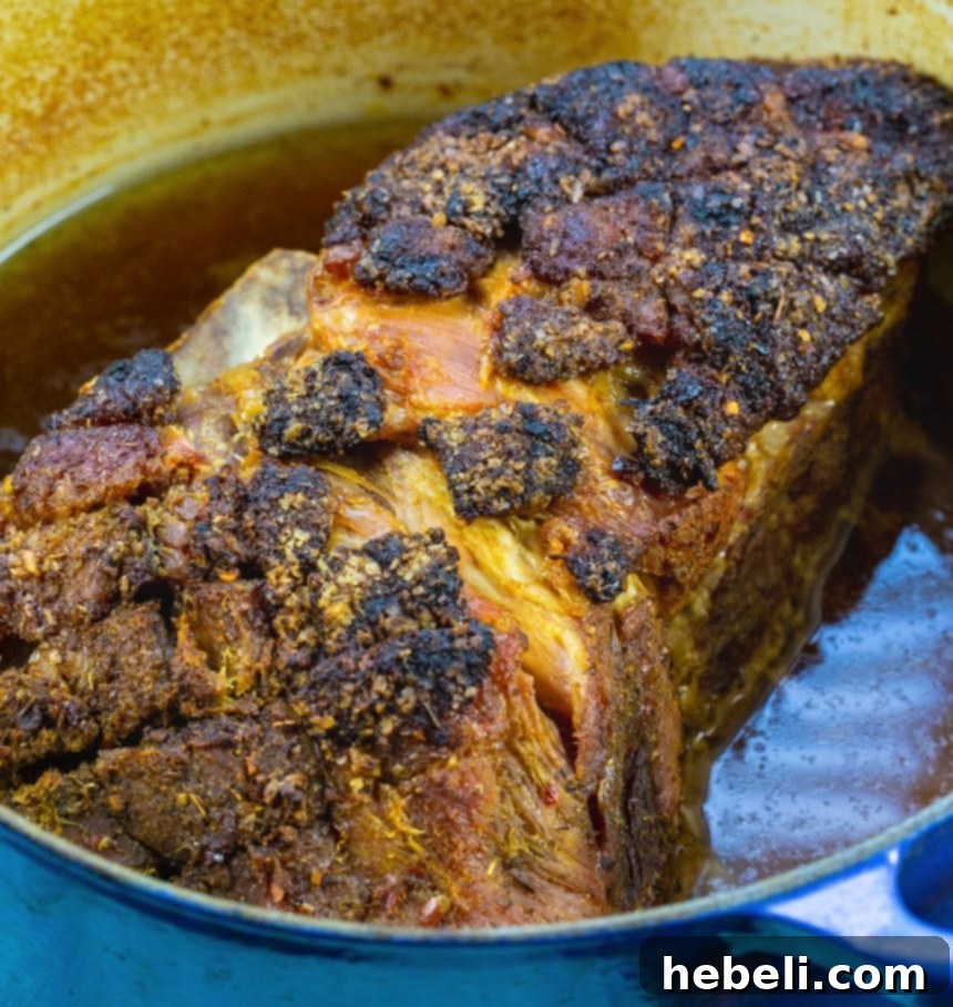 A succulent whole Cuban Pork Roast, slow-cooked to perfection in a classic Dutch oven, ready to be carved and enjoyed.
