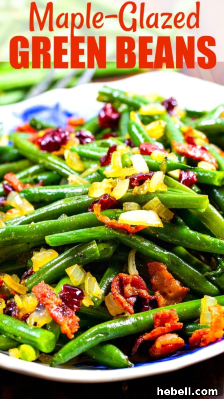 A vibrant side dish of Maple-Glazed Green Beans garnished with crispy bacon and bright red cranberries, served on a white platter.