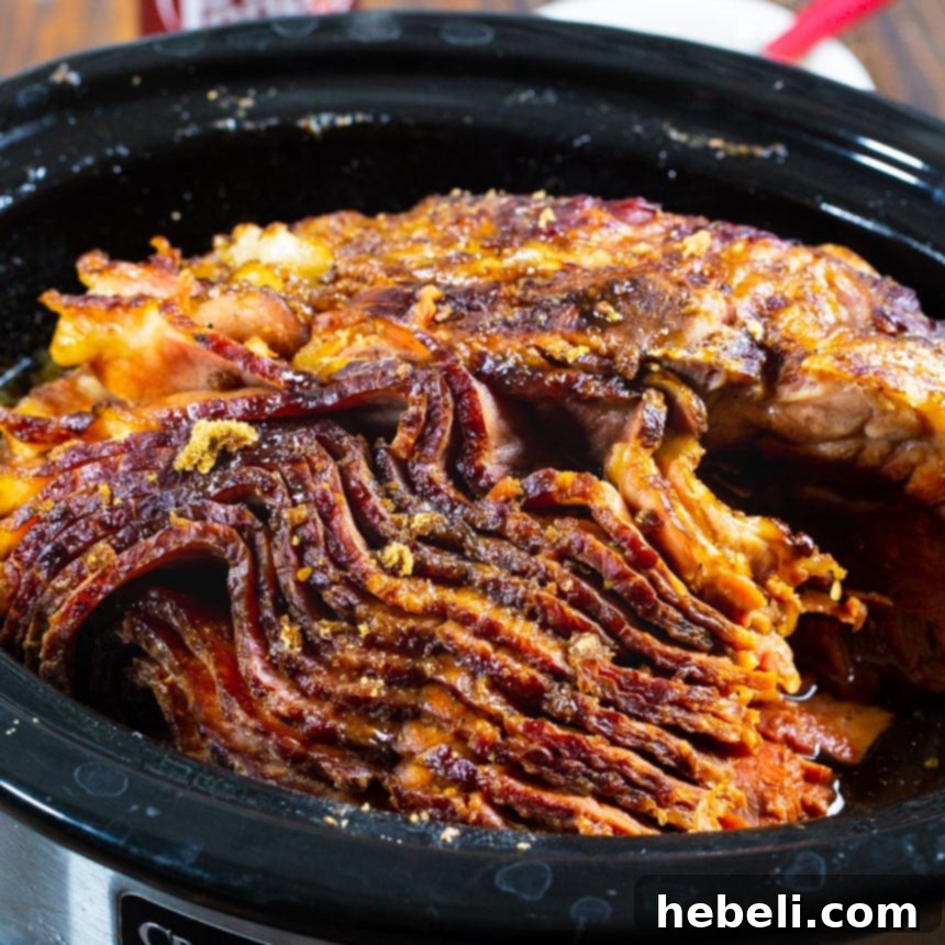 A succulent brown sugar and cola glazed ham cooking in a slow cooker, filling the kitchen with an irresistible aroma.
