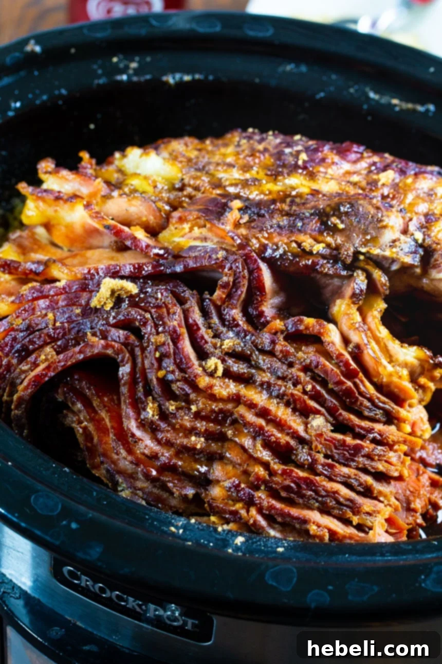 A perfectly cooked Slow Cooker Brown Sugar and Cola Glazed Ham, tender and ready to be served from the crock pot.