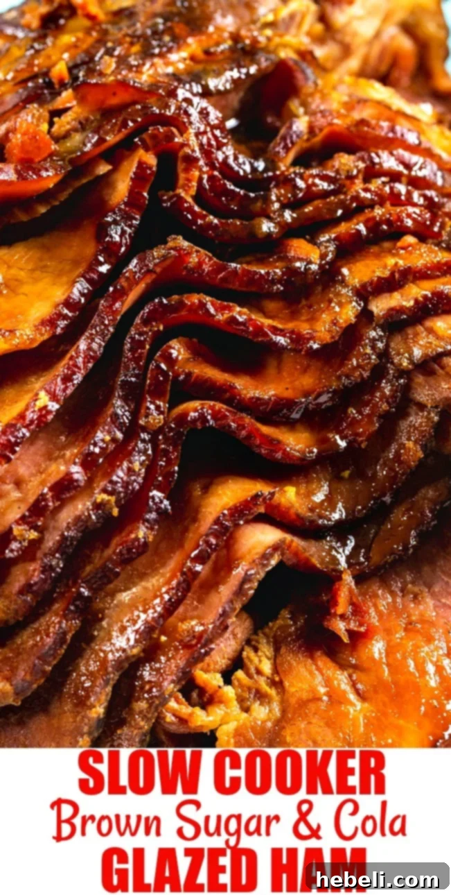 A close-up of a perfectly cooked Slow Cooker Brown Sugar and Cola Glazed Ham, showing its beautiful caramelized crust and tender slices.