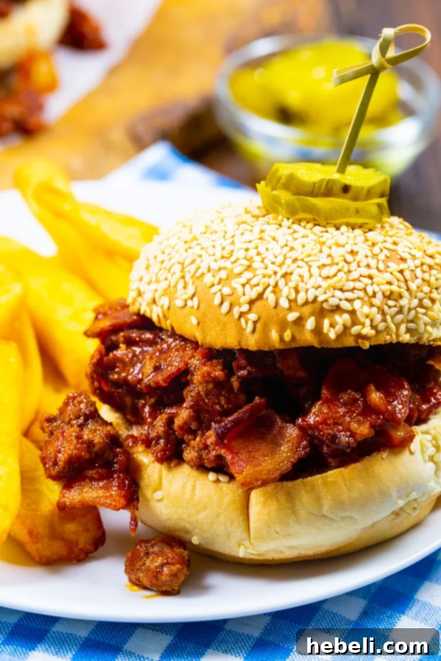 Sweet & Smoky Bacon Sloppy Joes 3 A perfectly assembled Brown Sugar Bacon Sloppy Joe sandwich on a plate, showcasing the generous filling.