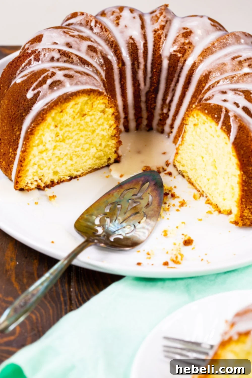 A slice of Five Flavor Pound Cake neatly presented on a white plate, showcasing its moist interior.