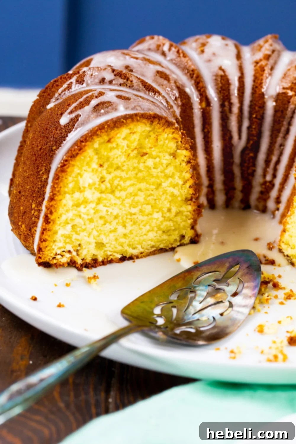 A close-up of a cut piece of Five Flavor Pound Cake, showing the moist crumb and glistening glaze.