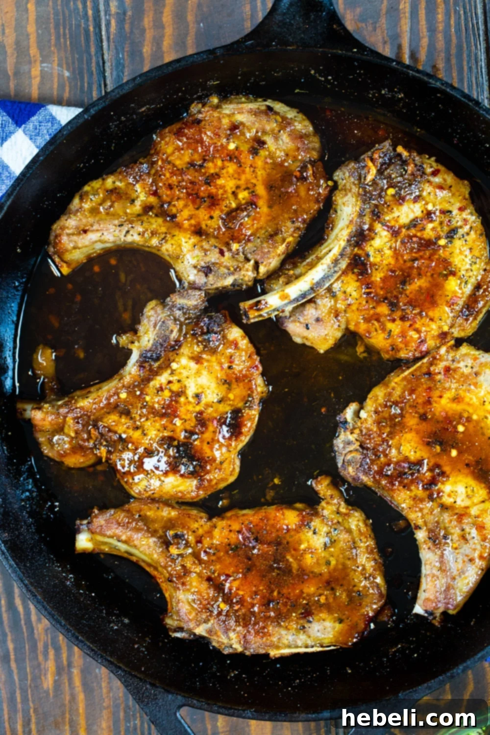 Sticky Brown Sugar Garlic Pork Chops 4 Thick-cut Brown Sugar Garlic Pork Chops sizzling in a cast iron pan, covered in a rich, caramelized glaze.