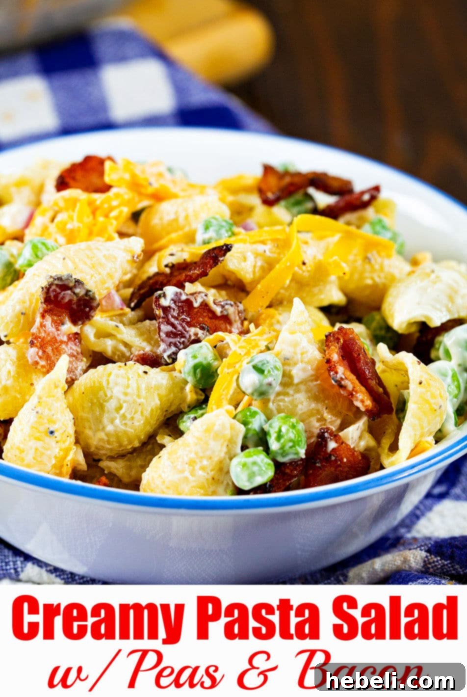 A large, vibrant serving bowl filled with Creamy Pasta Salad with Peas and Bacon, showcasing its appetizing texture and fresh, colorful ingredients.