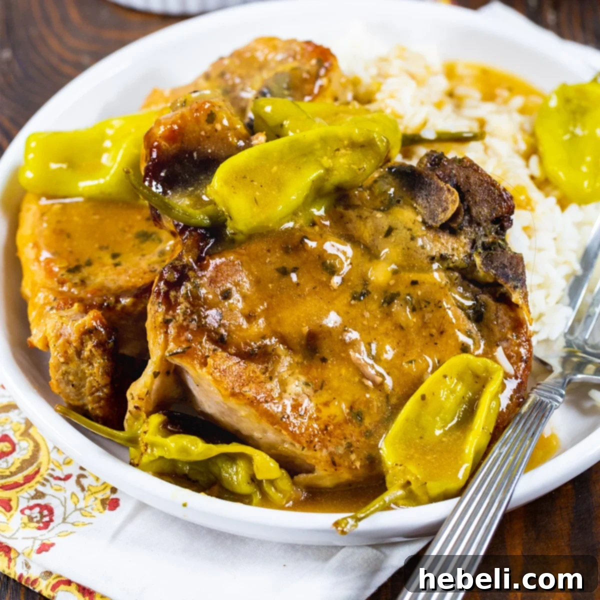 Slow Cooker Mississippi Magic Chops 2 Two perfectly cooked Slow Cooker Mississippi Pork Chops on a pristine white plate, garnished with fresh parsley.