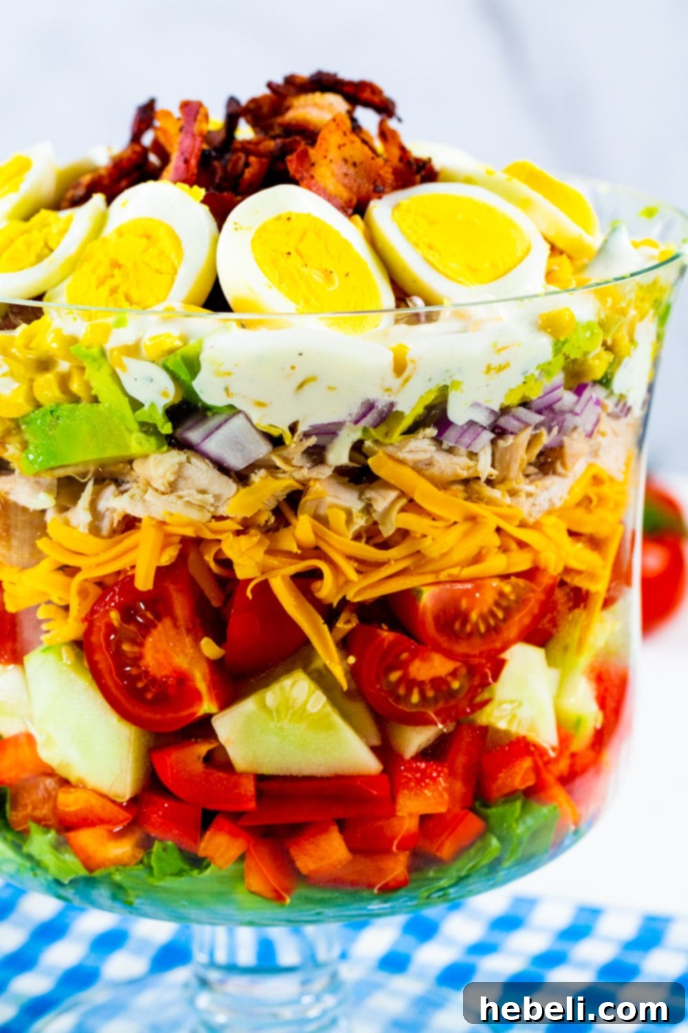 Layered Chicken Bacon Ranch Salad 3 Layer Salad topped with hard-boiled egg and bacon in a trifle dish.