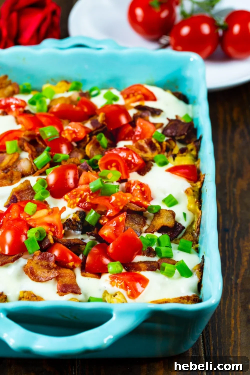 The fully assembled Hot Brown Casserole, beautifully topped with vibrant diced tomatoes and crispy bacon, ready for serving.