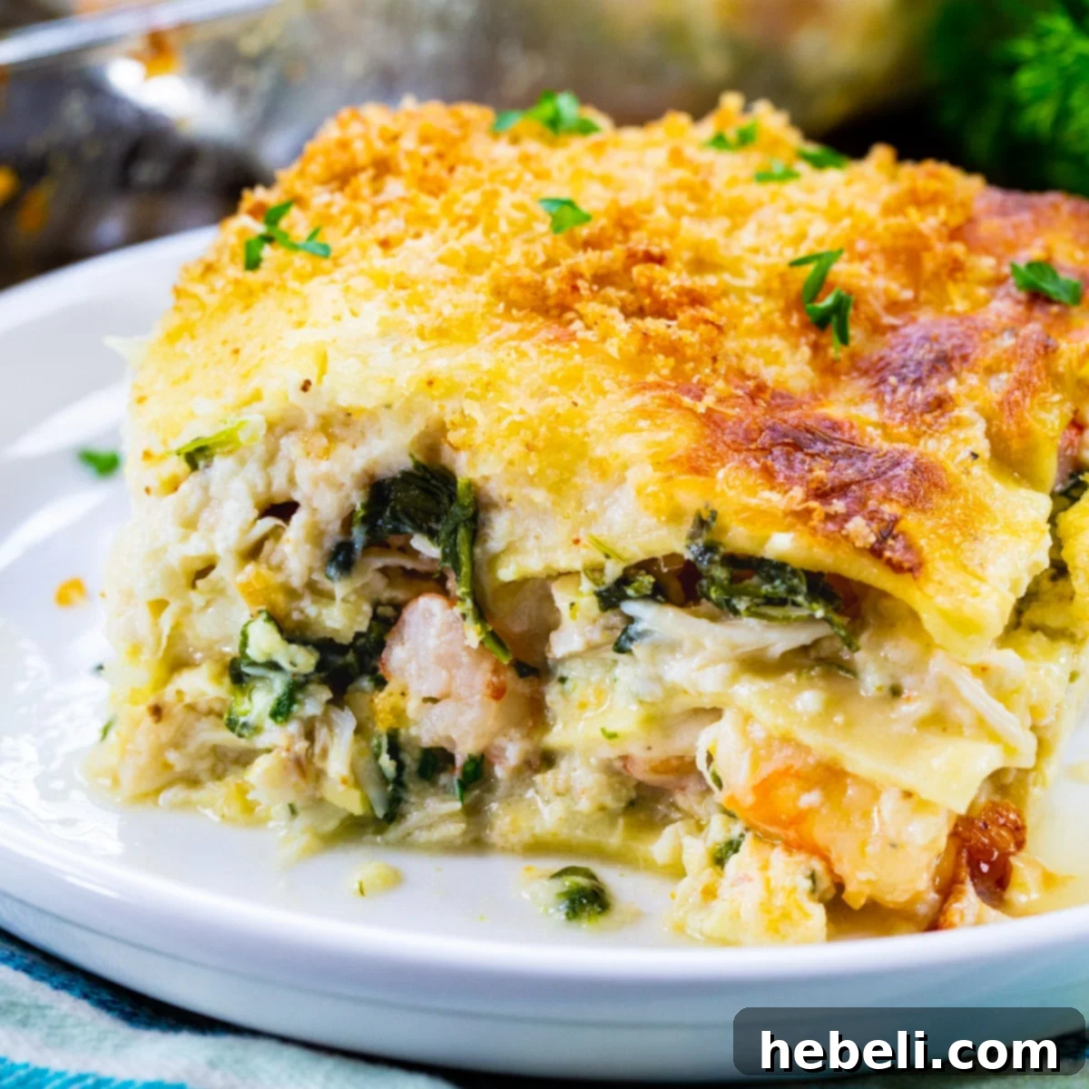 A perfectly sliced portion of White Seafood Lasagna on a plate, showcasing layers of pasta, creamy sauce, and visible seafood.