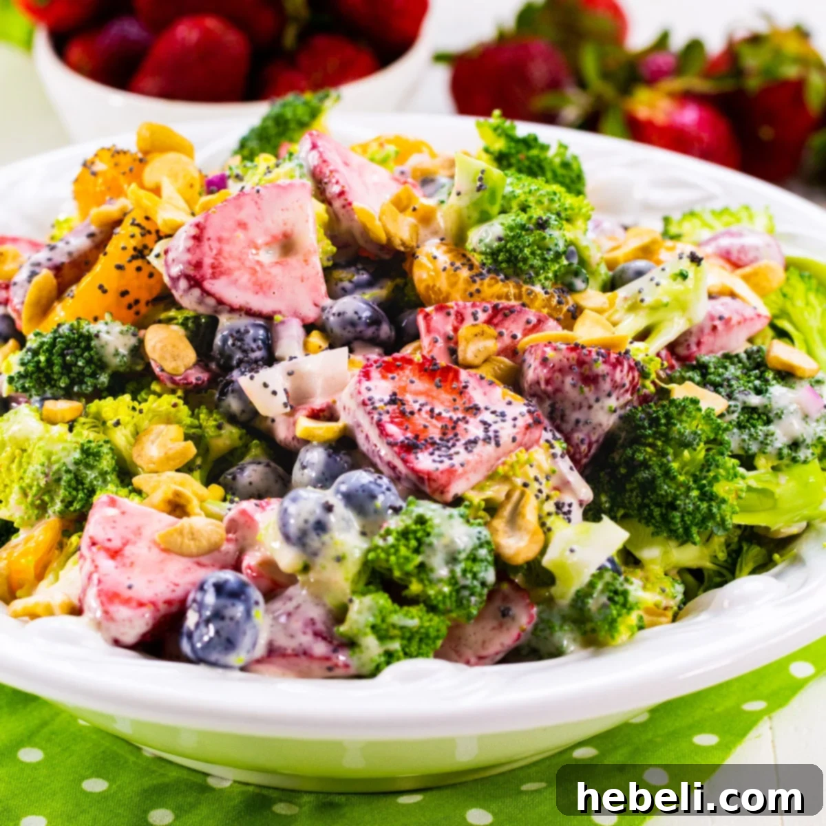 Berry Florets Fusion 2 A vibrant bowl of Broccoli Strawberry Salad, showcasing fresh broccoli, bright red strawberries, and golden mandarin oranges.