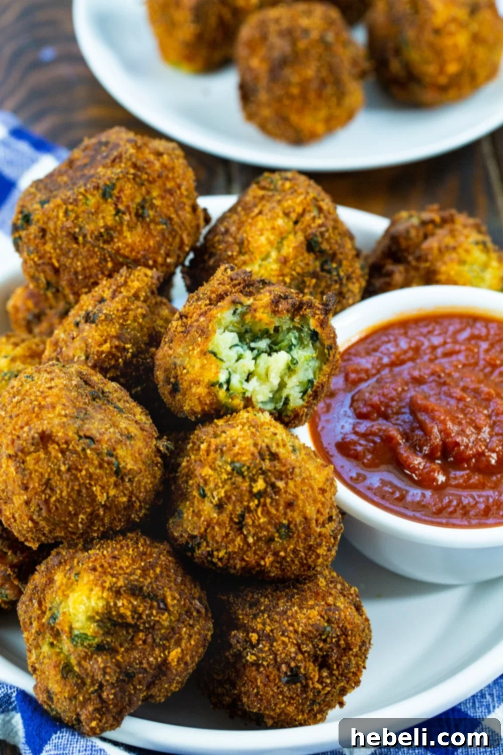 Close-up of freshly fried spinach cheese balls on a white plate, ready to be served.