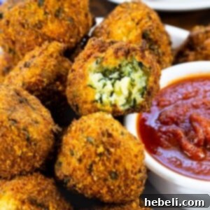 A close-up shot of golden, crispy Spinach Cheese Balls arranged on a platter, ready to be served.