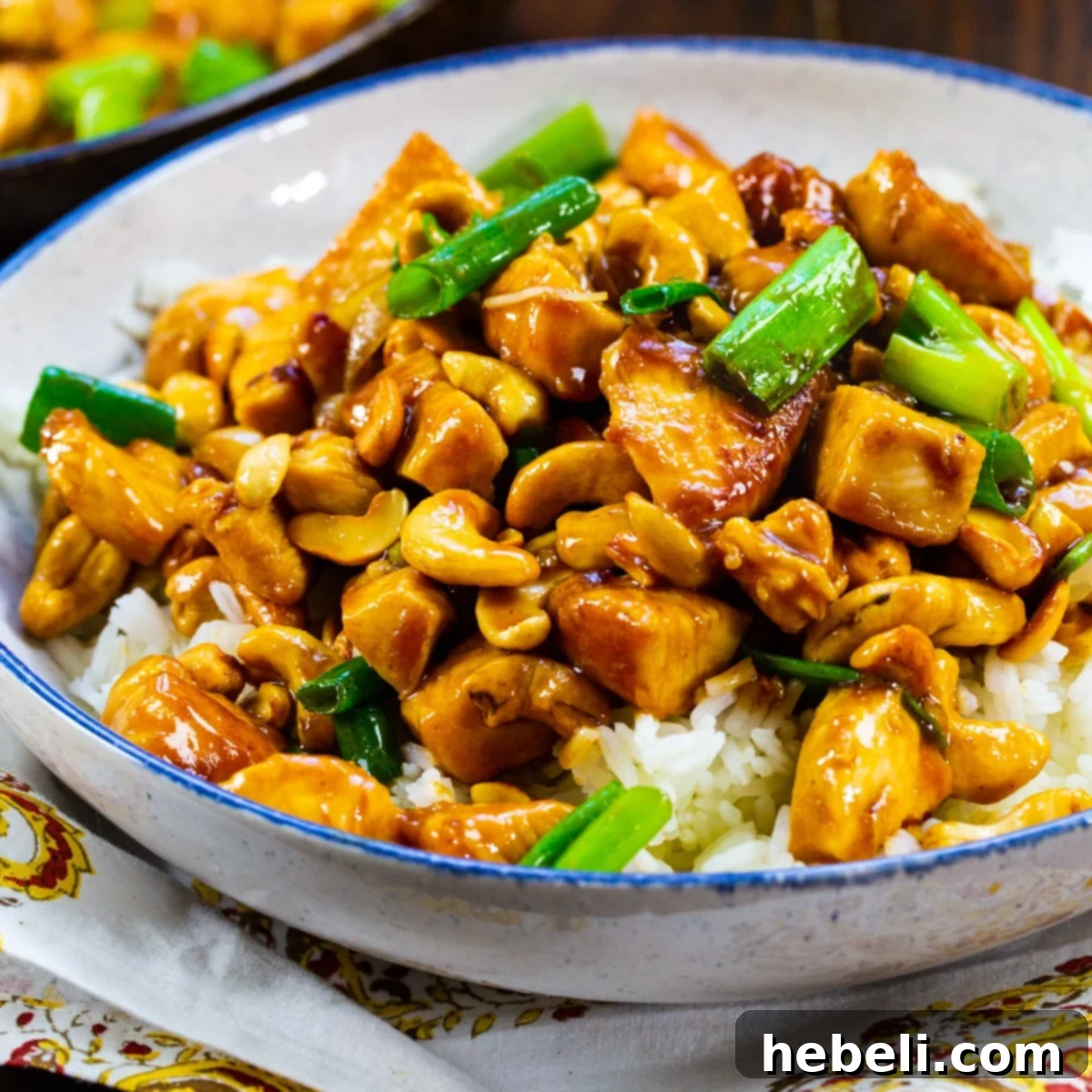Classic Cashew Chicken 2 A vibrant bowl of homemade Cashew Chicken served over fluffy white rice, garnished with green onions and ready to be enjoyed.