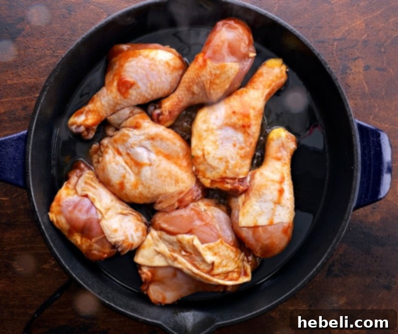 Caramelized Southern Chicken 4 Chicken pieces carefully placed into a hot cast iron pan for searing until golden brown.